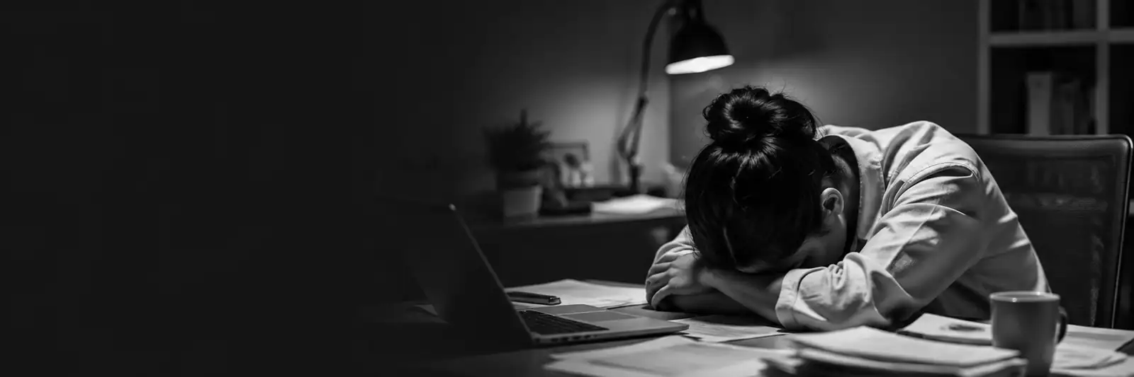 Salariée épuisée, tête posée sur ses bras devant son ordinateur, burn-out au travail