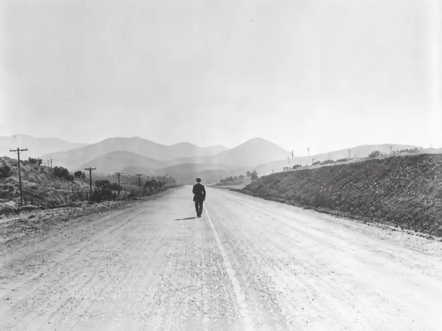Personne seule marchant sur une route, symbole de l'isolement professionnel