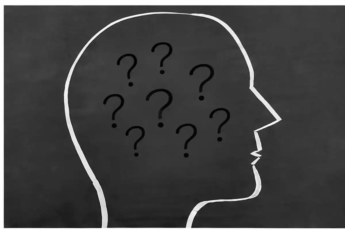 Silhouette de tête remplie de points d'interrogation symbolisant les doutes face au harcèlement au travail